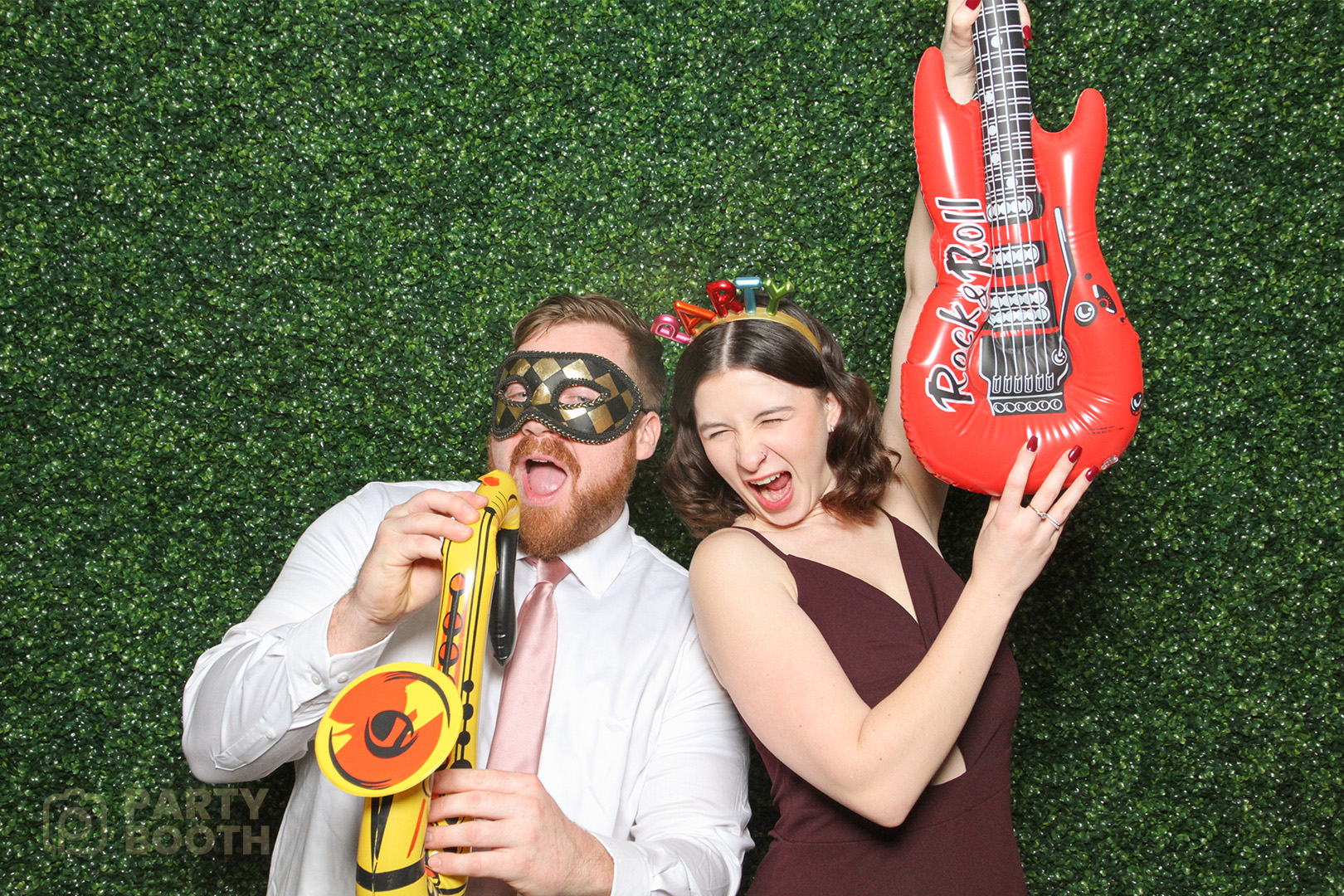 couple posing with wedding photo booth props